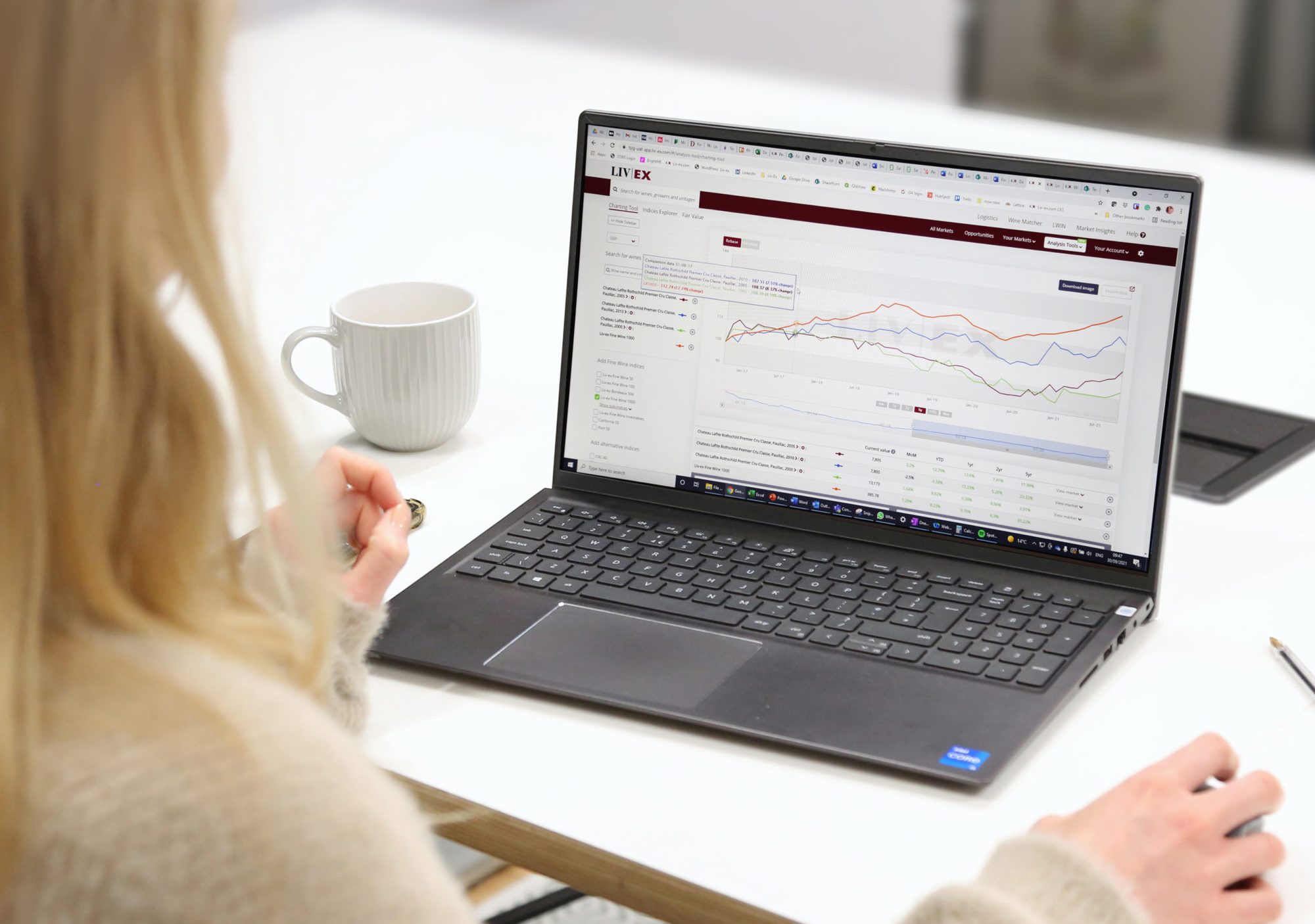 Reviewing fine wine market pricing on a laptop
